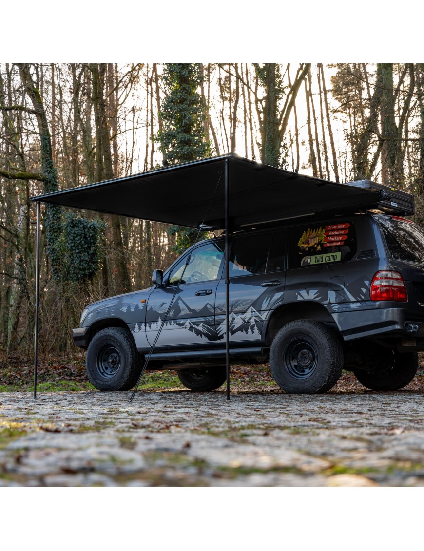 Black Wild Camp 2x2.5 m awning extended from the side of an off-roader on two poles