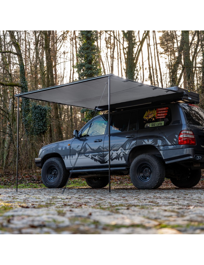 Szara markiza Wild Camp 2,5x3 m rozwinięta z boku terenówki na dwóch wspornikach