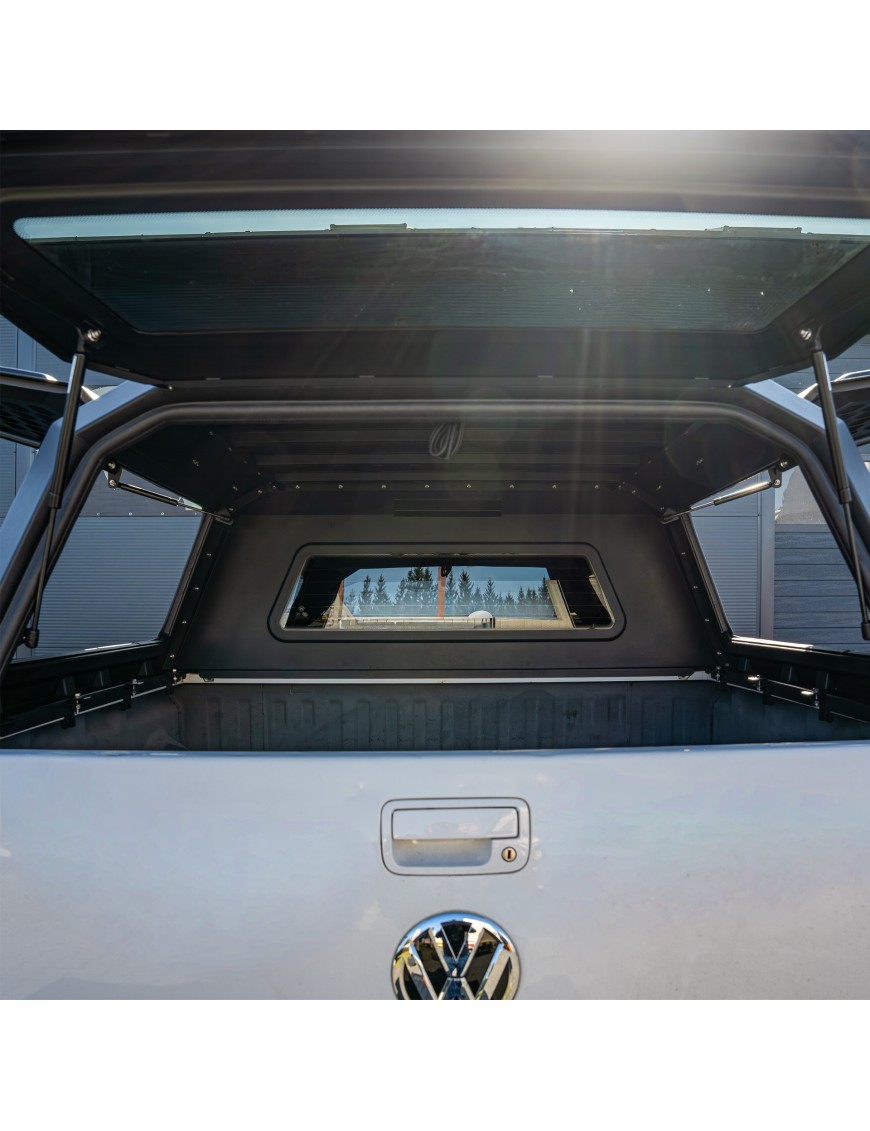 Inside the load bed under a Wild Camp hardtop canopy seen through the open rear door