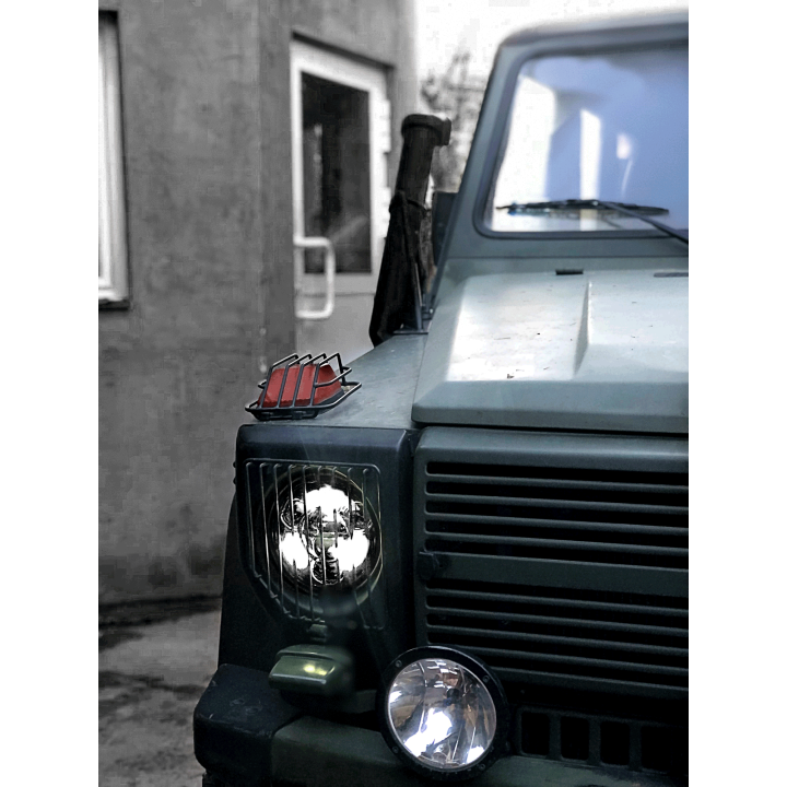 Przód terenowego Mercedesa z włączonym reflektorem Next2, ujęcie z boku