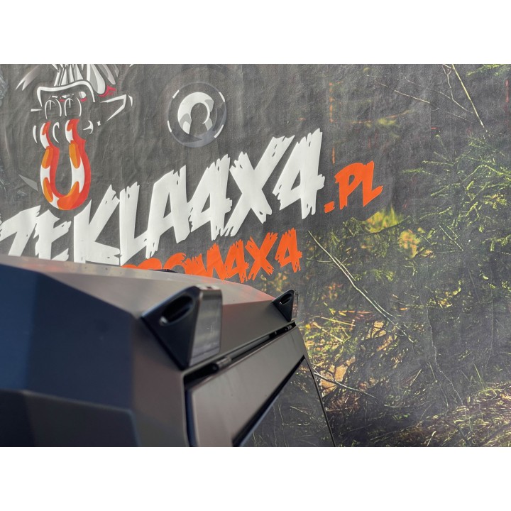 Lampa Hella na narożniku czarnej zabudowy, w tle baner Szekla4x4